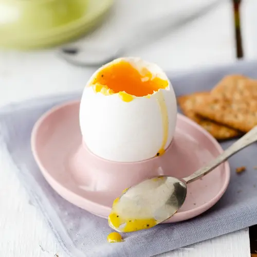 Boiled egg with a spoon and toast.